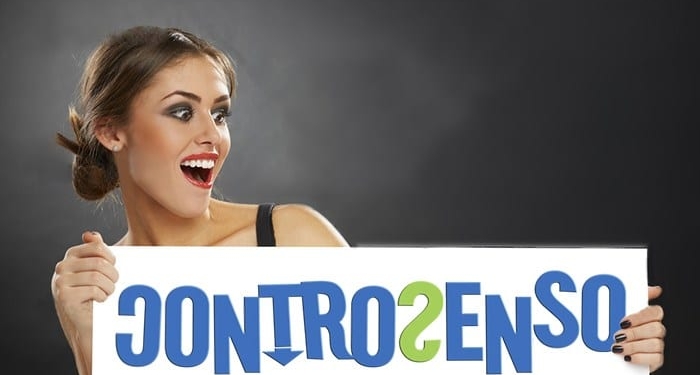Excited joyful young woman holding blank white billboard against dark background.