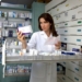 Beautiful female model pharmacist looking at medicine