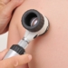 Dermatologist examines child patient birthmark with dermatoscope