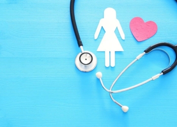 women healf Insurance . concept image of Stethoscope and female figure on wooden table. top view