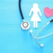 women healf Insurance . concept image of Stethoscope and female figure on wooden table. top view