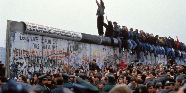 BERLIN, GERMANY - NOVEMBER 12: A man celebrates on the Berlin wall on November 12, 1989 in Berlin, Germany.(Photo by Pool CHUTE DU MUR BERLIN/Gamma-Rapho via Getty Images)