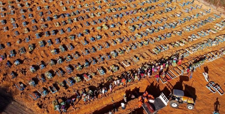 Aerial view of cemetery workers unloading a coffin from a truck at an area where new graves have been dug at the Parque Taruma cemetery, during the COVID-19 coronavirus pandemic in Manaus, Amazonas state, Brazil, on April 21, 2020. - The new area of the cemetery houses graves for suspected and confirmed victims of the COVID-19 coronavirus pandemic. (Photo by MICHAEL DANTAS / AFP)