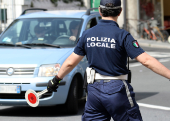 San Remo, Italy - June 10, 2018: Italian Policeman (Polizia Locale) in Uniform Controlling Road Traffic in The City Center of San Remo, Liguria, Italy