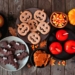 Rustic Halloween treat table scene over a dark wood background. Top view. Variety of candied apples, cookies, candy and sweets.